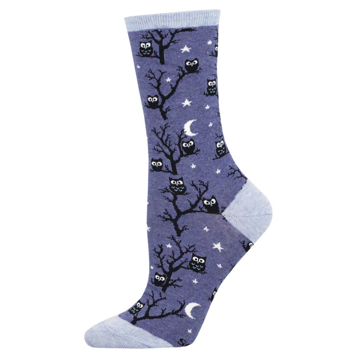 A pair of denim blue crew socks with a pattern of owls sitting on branches against a night sky background.
