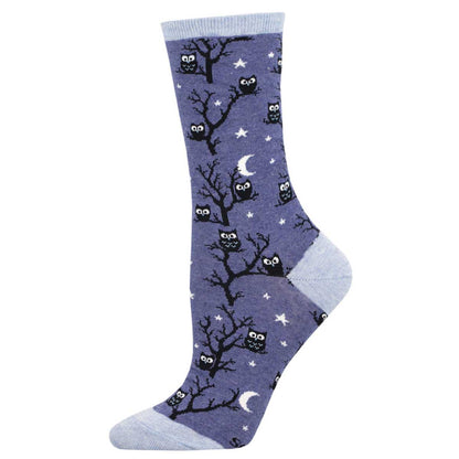 A pair of denim blue crew socks with a pattern of owls sitting on branches against a night sky background.