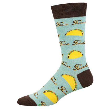 A pair of blue crew socks with a pattern that includes the phrase 'Taco Tuesday' and illustrations of tacos.